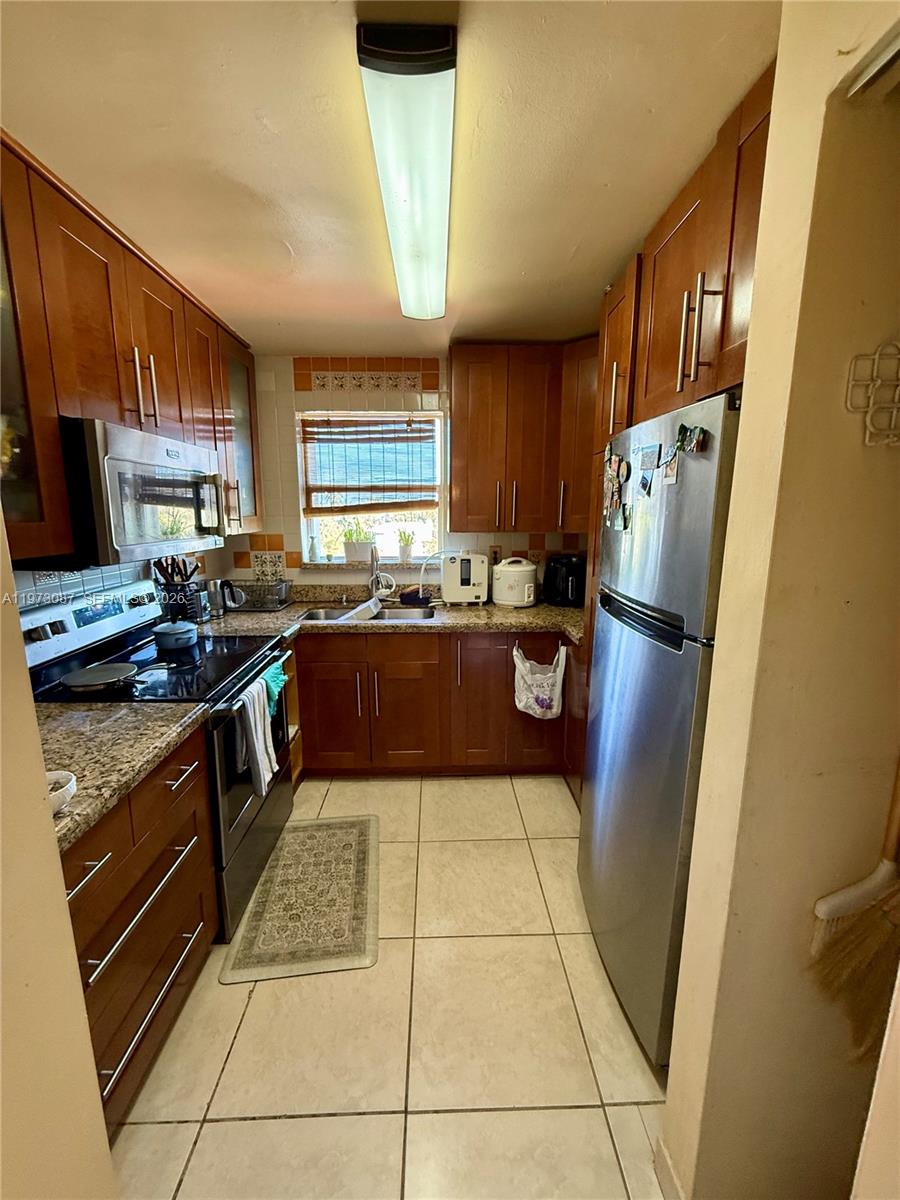 1236 Alton Road, Unit 401 Miami Beach, FL 33139 - Photo 8 of 14 a kitchen with stainless steel appliances granite countertop a refrigerator stove and a sink