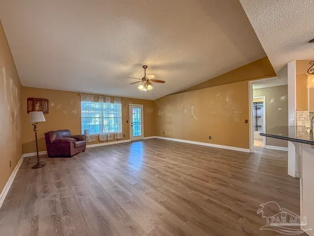 a view of empty room with wooden floor