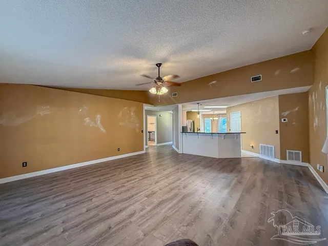 a view of a livingroom with a ceiling fan and wooden floor