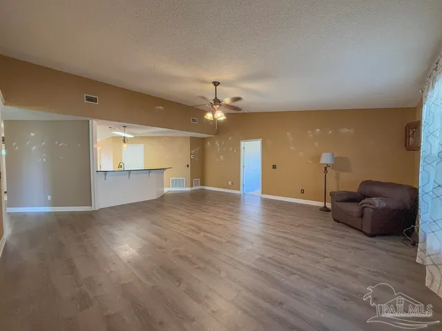 a view of a livingroom with a window and wooden floor