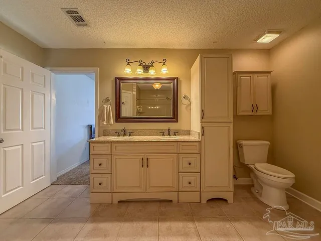 a view of a hallway with wooden floor and a bathroom