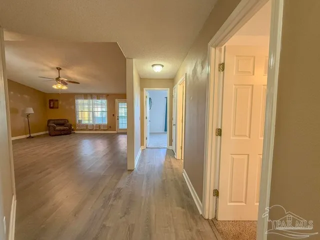 an empty room with windows and fan