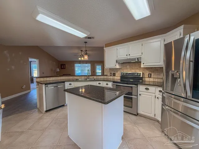 a kitchen with white cabinets and stainless steel appliances