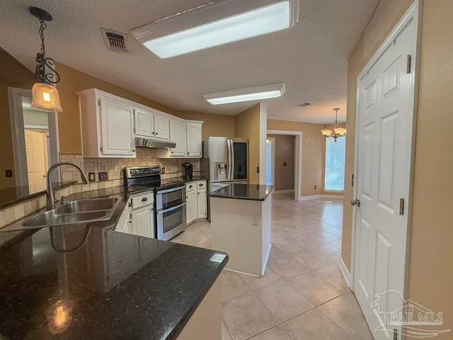 a view of a kitchen with refrigerator and sink