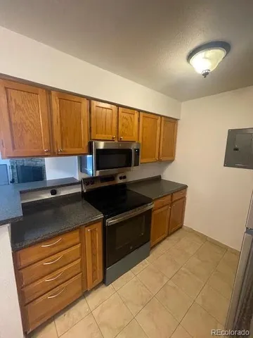 a kitchen with granite countertop a sink and a stove
