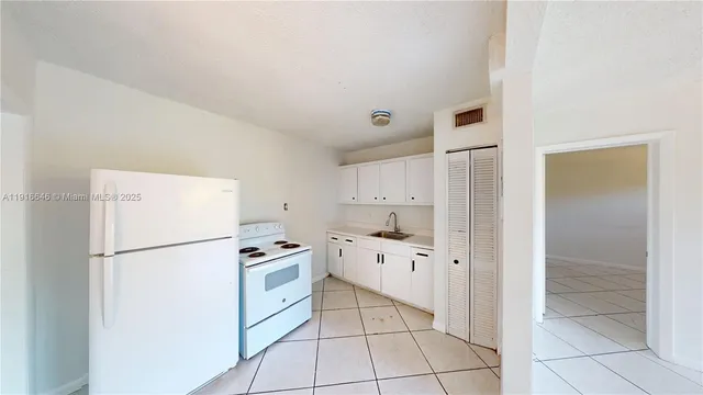 a kitchen with white cabinets and white appliances