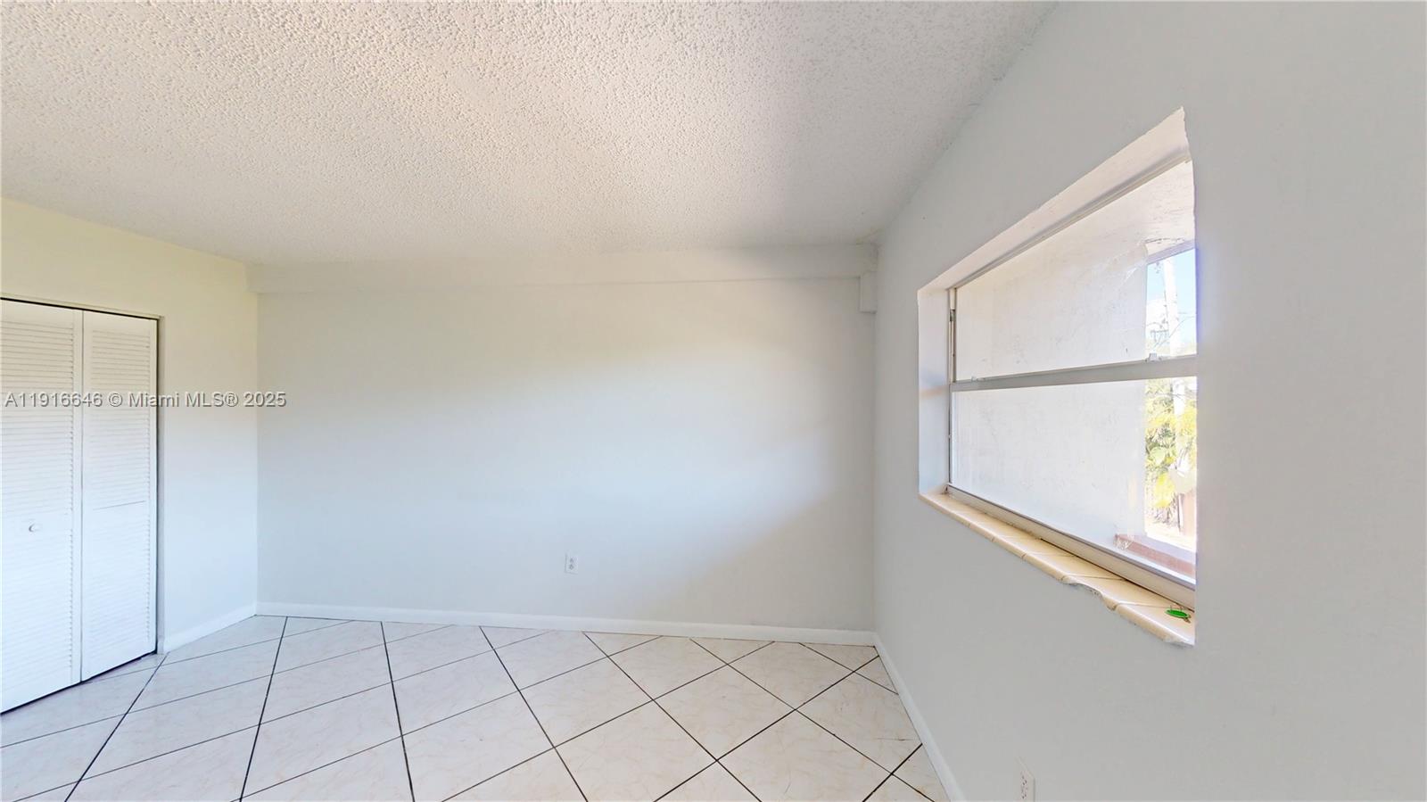 1825 Southwest 67th Avenue, Unit 24 West Miami, FL 33155 - Photo 4 of 11 an empty room with windows