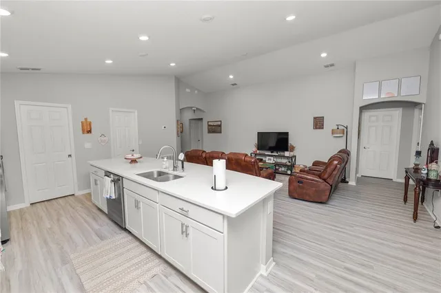 a view of a living room a sink a flat screen tv and a couch