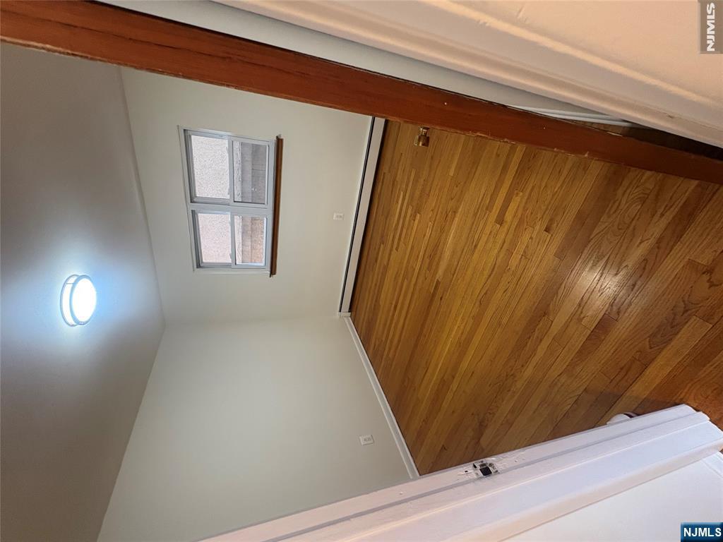 399 Walker Street, Unit 1B Fairview, NJ 07022 - Photo 9 of 11 a view of a big room with wooden floor and windows