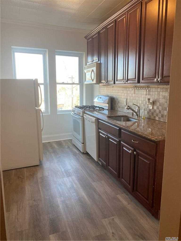 a kitchen with stainless steel appliances granite countertop wooden cabinets a sink and dishwasher with wooden floor