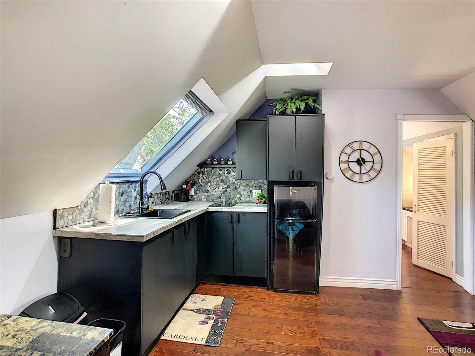 124 South Sherman Street, Unit UPSTAIRS Denver, CO 80209 - Photo 1 of 35 a kitchen with stainless steel appliances granite countertop a refrigerator a stove a sink and a dining table with wooden floor