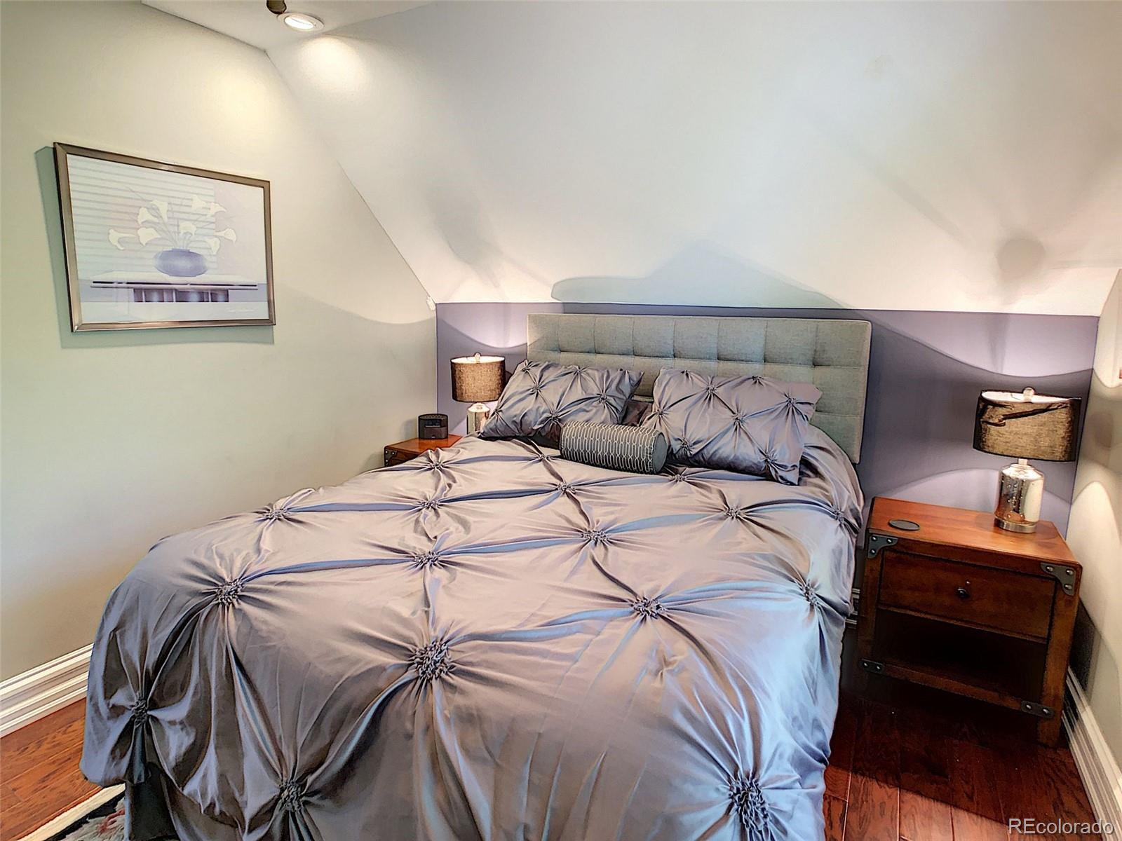 124 South Sherman Street, Unit UPSTAIRS Denver, CO 80209 - Photo 11 of 35 a bedroom with a bed and a lamp on dresser