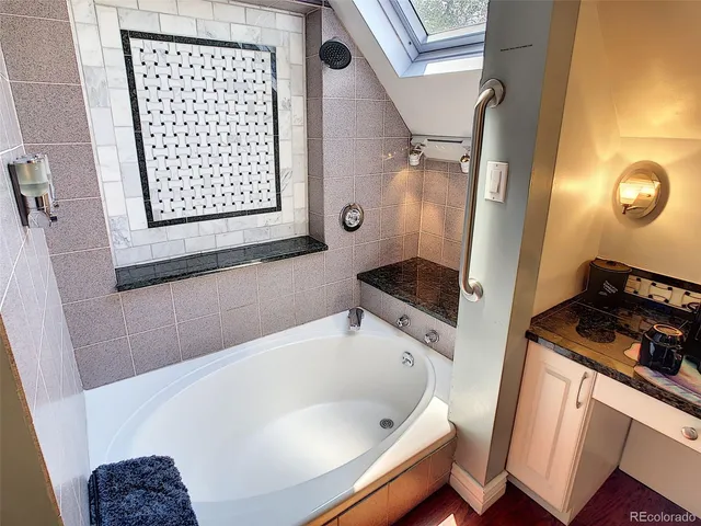 a bathroom with a bathtub sink and mirror