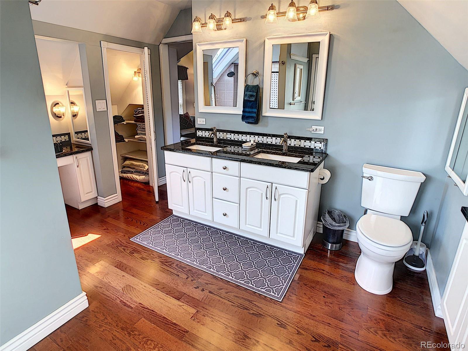 124 South Sherman Street, Unit UPSTAIRS Denver, CO 80209 - Photo 19 of 35 a spacious bathroom with a toilet a sink and a mirror