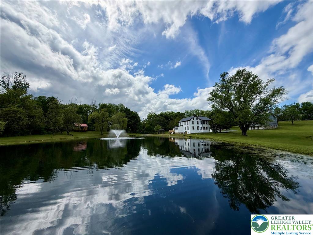 940 Jacktown Road Bangor, PA 18013 - Photo 4 of 33 Reflecting tranquil waters and a vibrant green landscape, this property offers serene lakeside living.