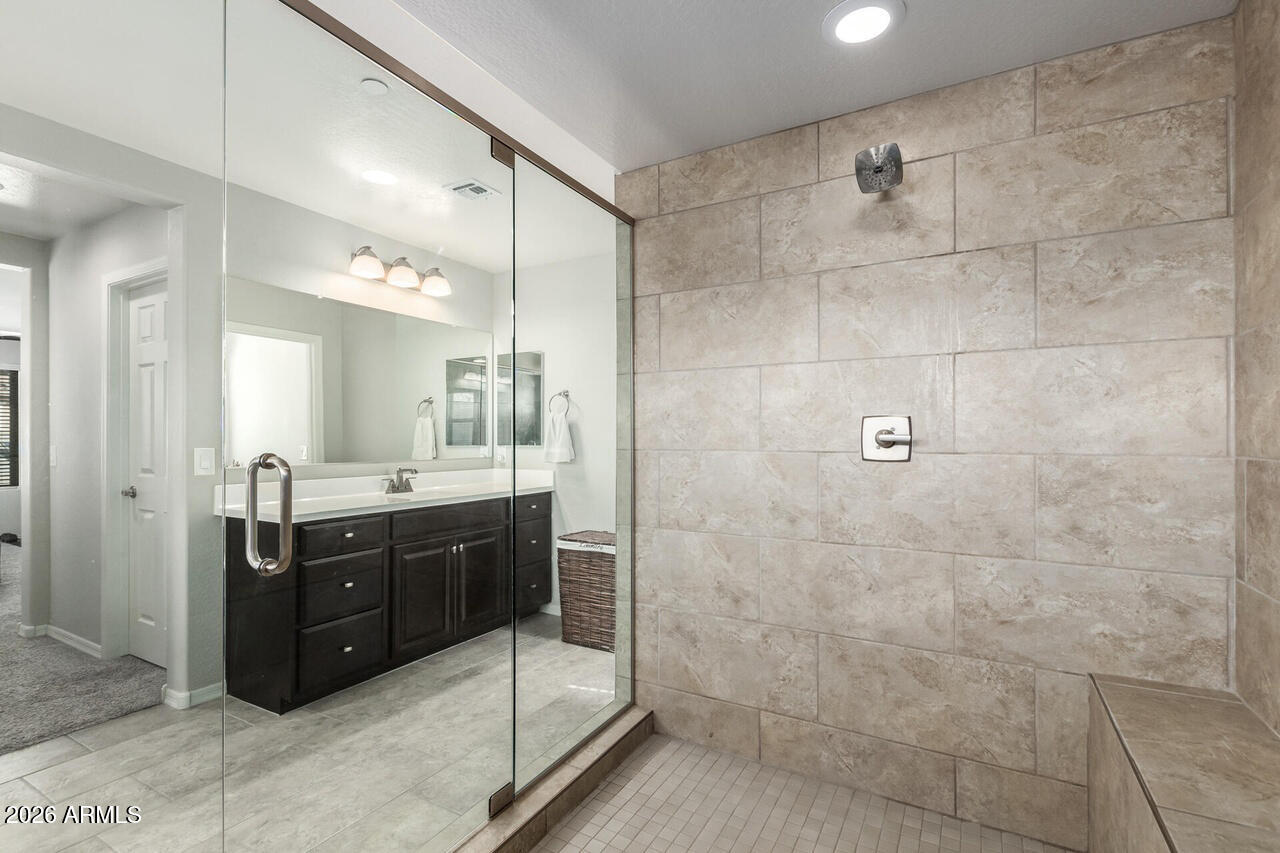 21188 West Almeria Road Buckeye, AZ 85396 - Photo 16 of 43 a bathroom with a granite countertop sink mirror and shower