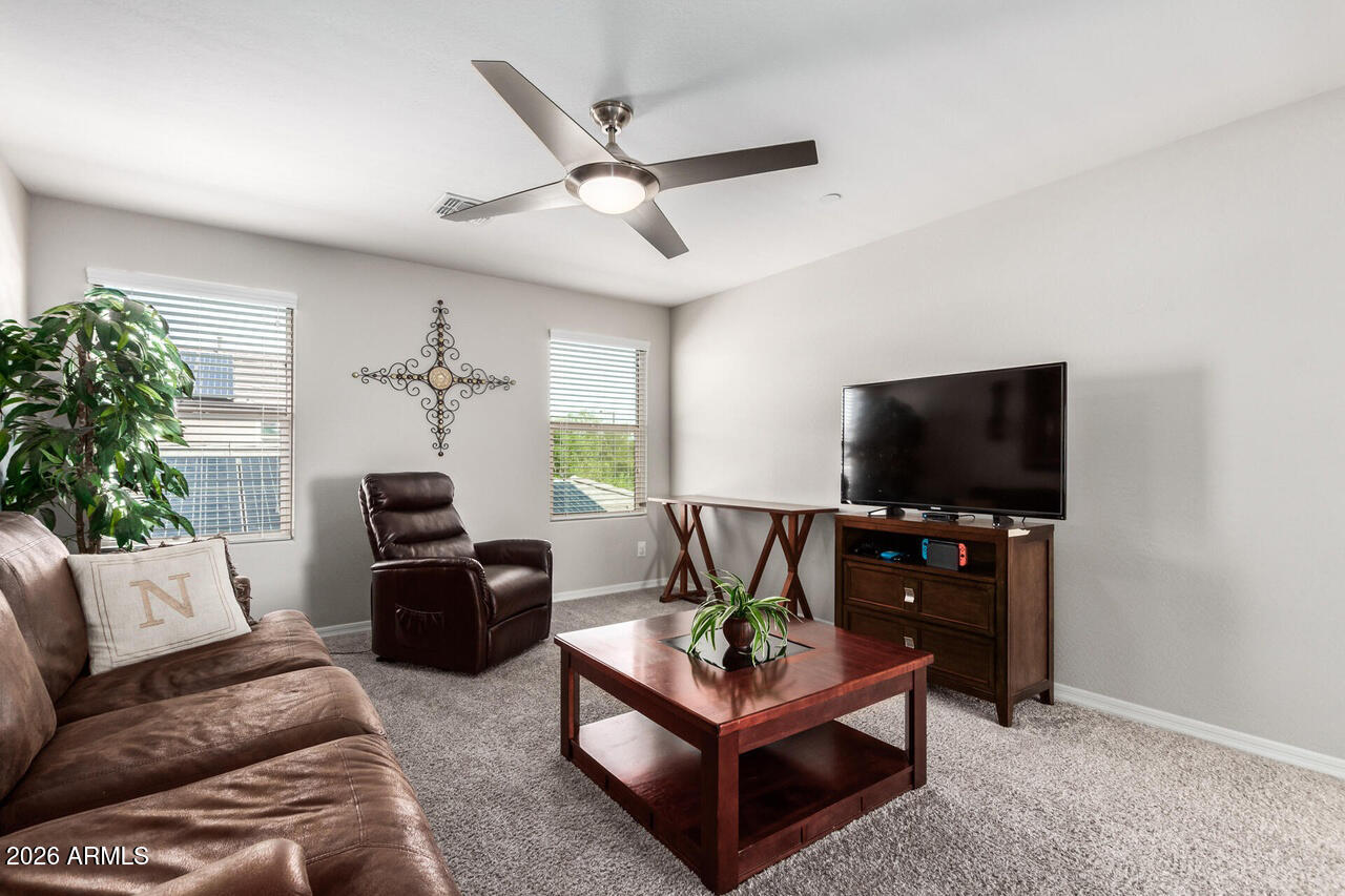 21188 West Almeria Road Buckeye, AZ 85396 - Photo 19 of 43 a living room with furniture and a flat screen tv