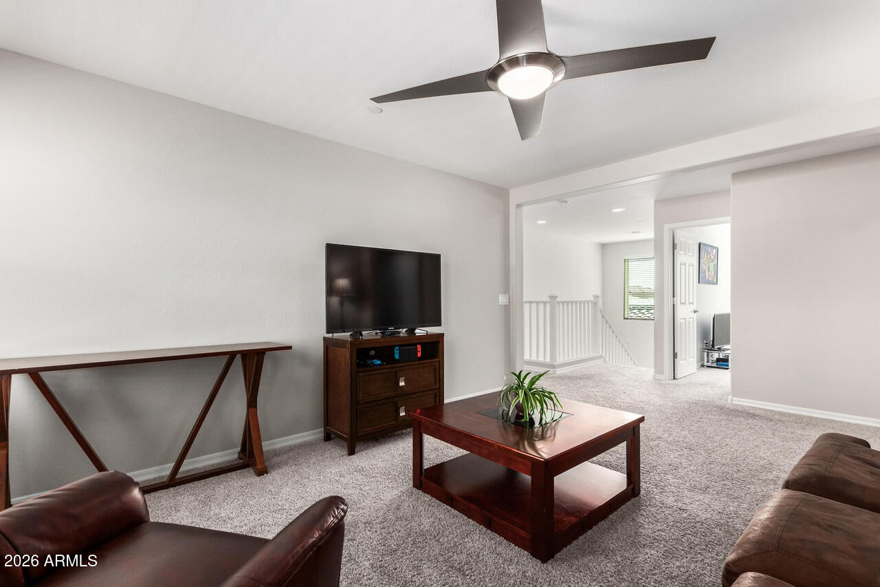 21188 West Almeria Road Buckeye, AZ 85396 - Photo 20 of 43 a living room with furniture a ceiling fan and a rug