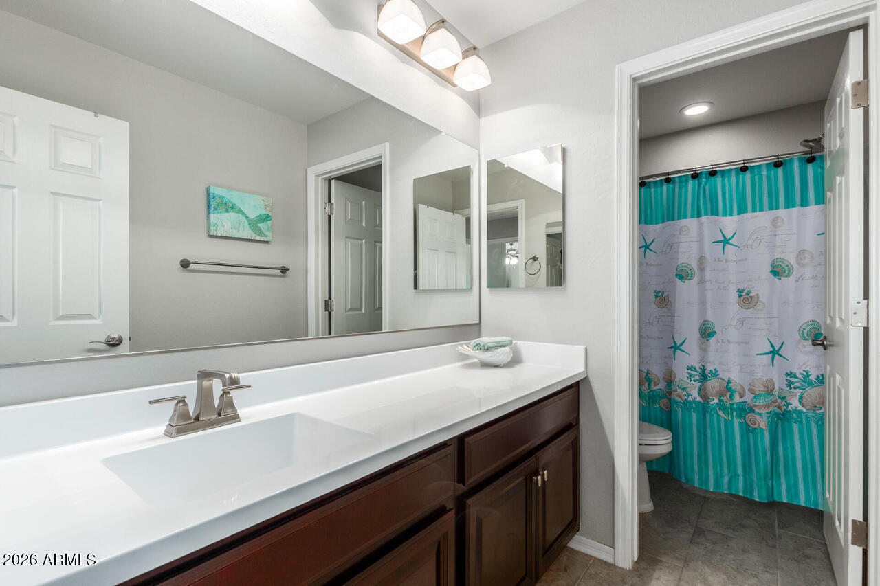 21188 West Almeria Road Buckeye, AZ 85396 - Photo 22 of 43 a bathroom with a sink and a mirror