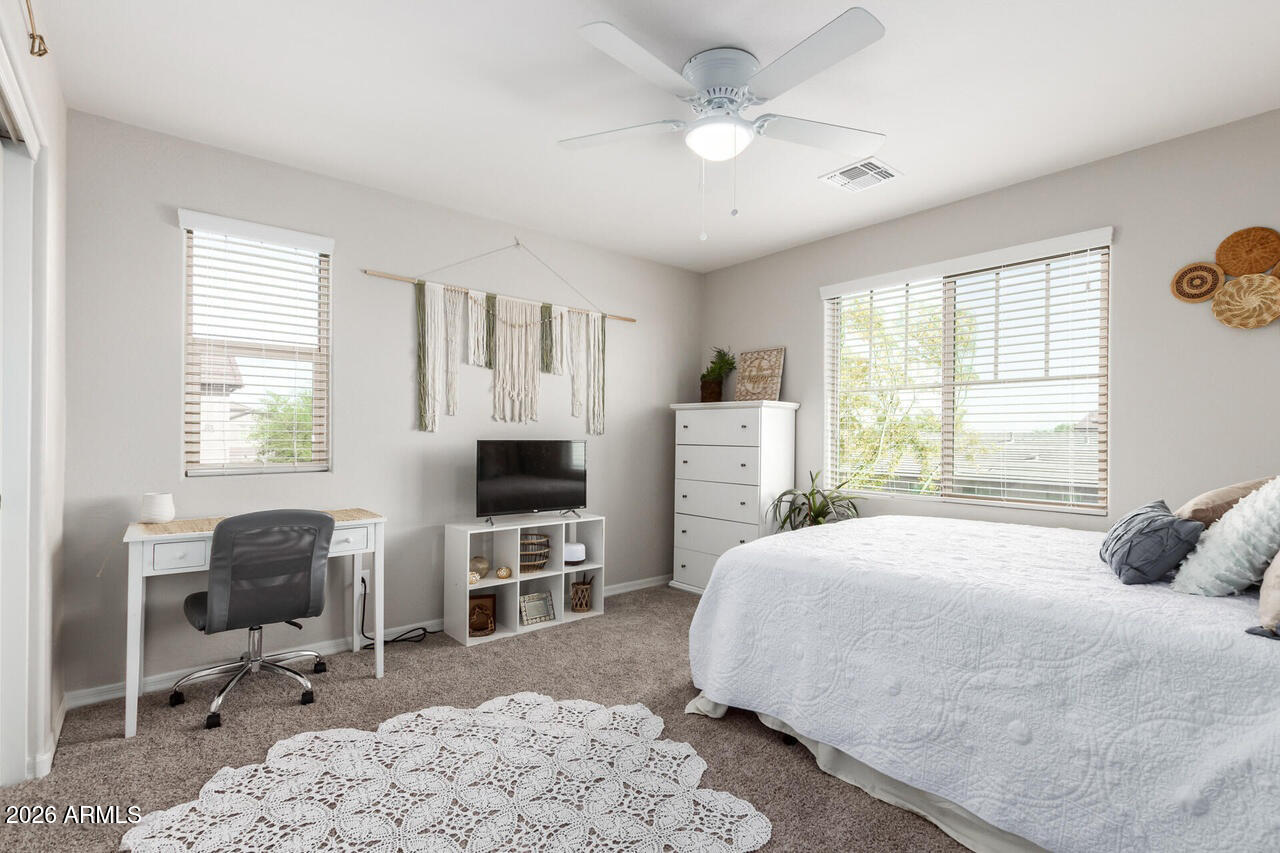 21188 West Almeria Road Buckeye, AZ 85396 - Photo 23 of 43 a bedroom with a bed a computer on desk and a dresser