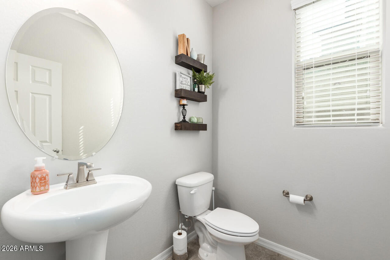 21188 West Almeria Road Buckeye, AZ 85396 - Photo 24 of 43 a bathroom with a sink a toilet and mirror