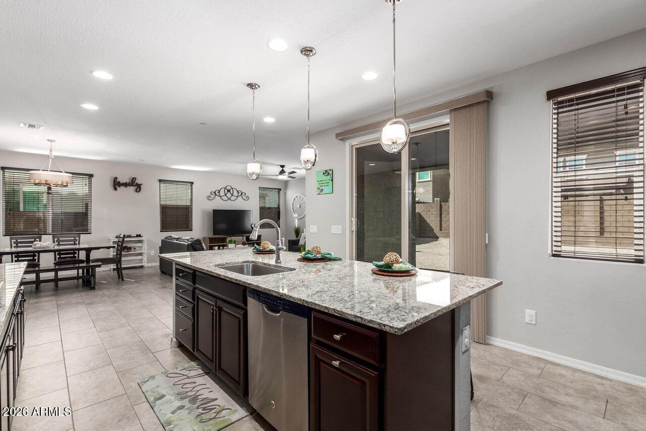 21188 West Almeria Road Buckeye, AZ 85396 - Photo 4 of 43 a kitchen with a stove a kitchen island a sink and a refrigerator