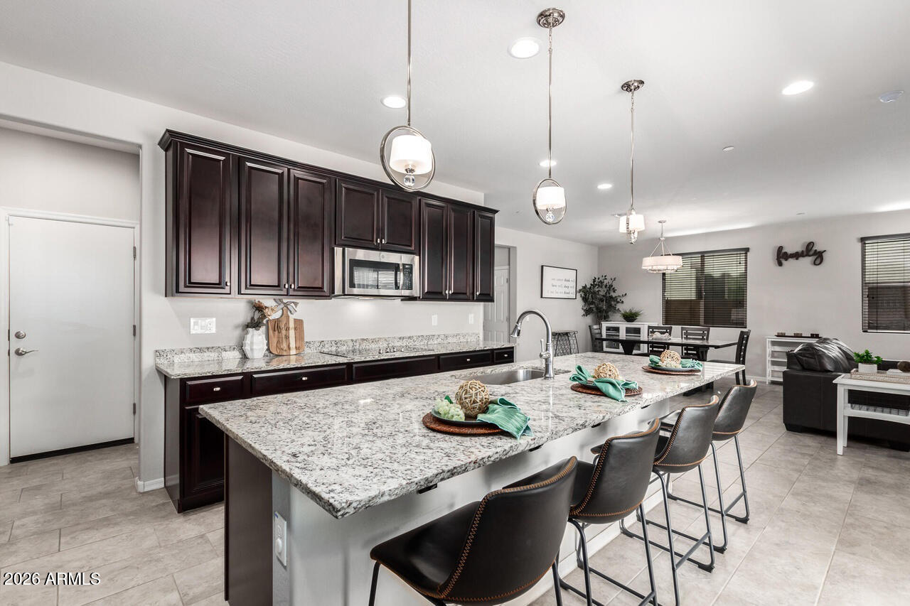 21188 West Almeria Road Buckeye, AZ 85396 - Photo 5 of 43 a kitchen with a table chairs stove and microwave