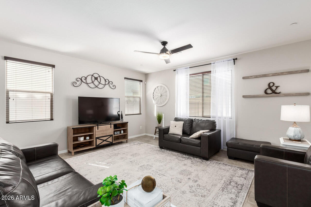 21188 West Almeria Road Buckeye, AZ 85396 - Photo 6 of 43 a living room with furniture and a flat screen tv