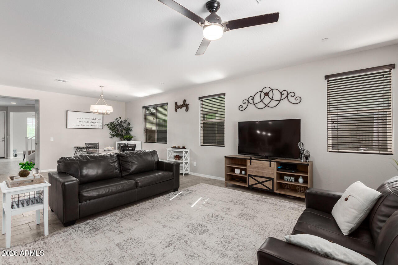 21188 West Almeria Road Buckeye, AZ 85396 - Photo 10 of 43 a living room with furniture and a flat screen tv
