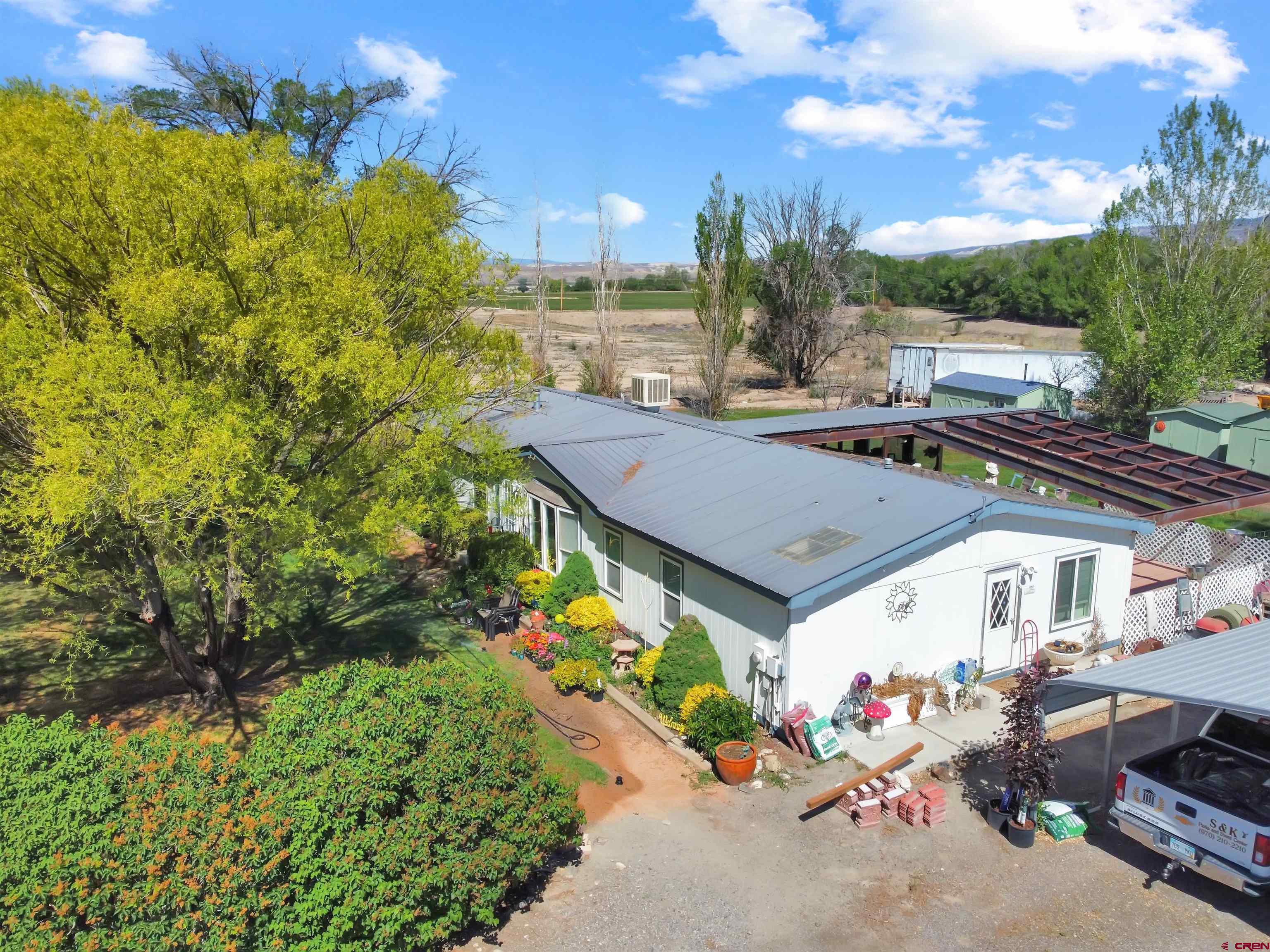 5955 Sawmill Mesa Road Delta, CO 81416 - Photo 1 of 32 a aerial view of a house with table and chairs plants and large tree