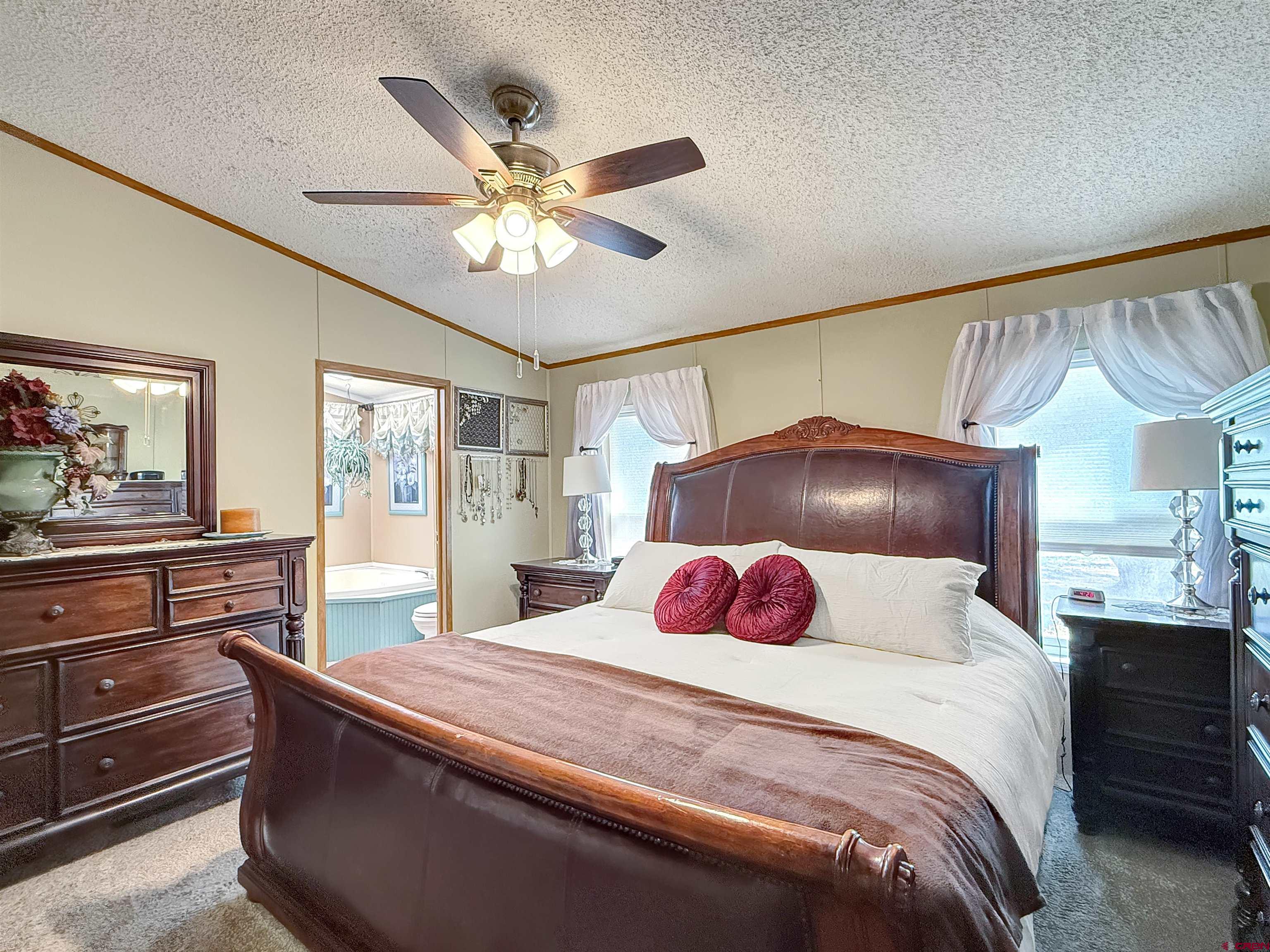 5955 Sawmill Mesa Road Delta, CO 81416 - Photo 13 of 32 a bedroom with a large bed and a chandelier