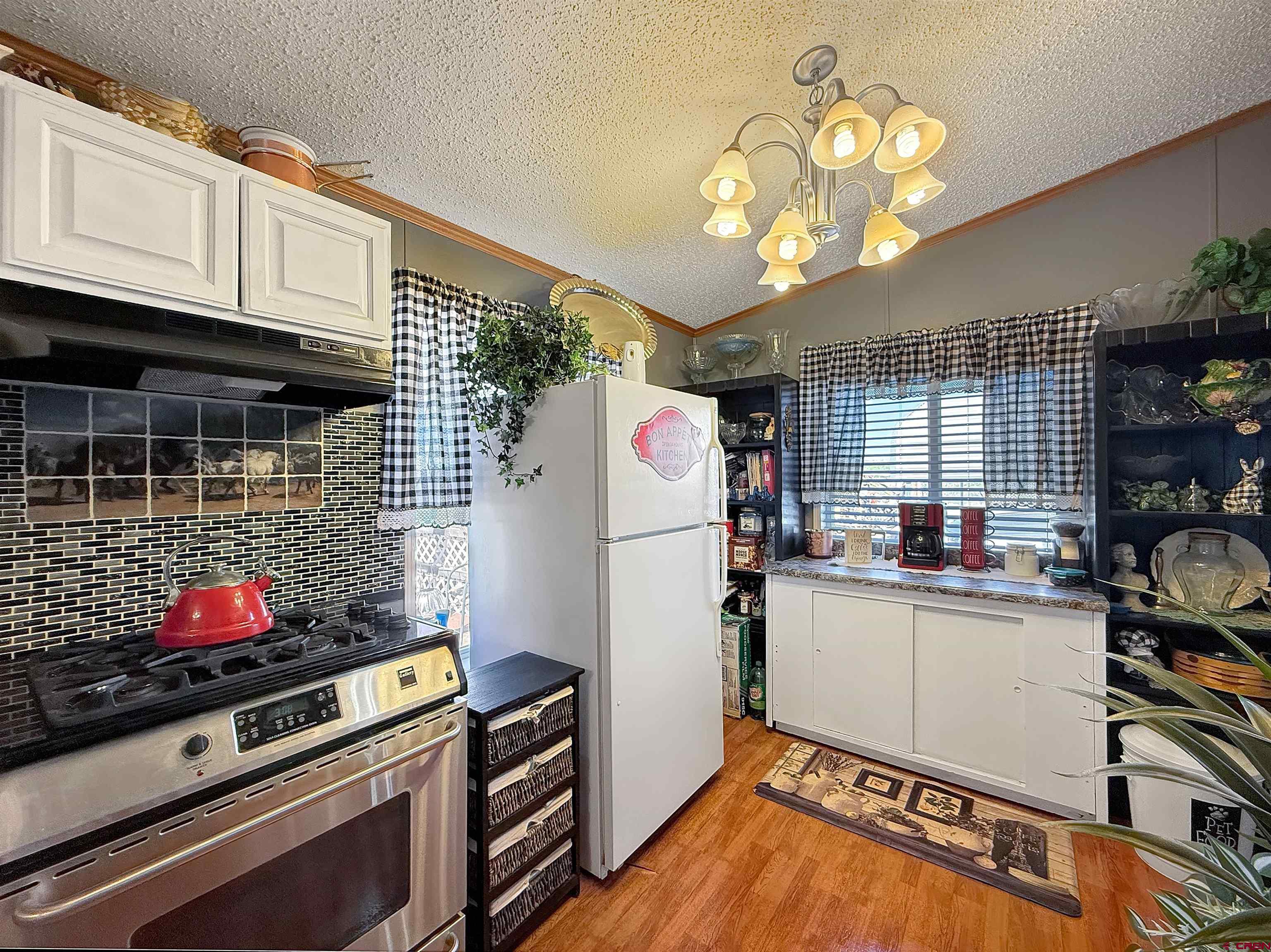 5955 Sawmill Mesa Road Delta, CO 81416 - Photo 7 of 32 a kitchen with a refrigerator and a stove top oven