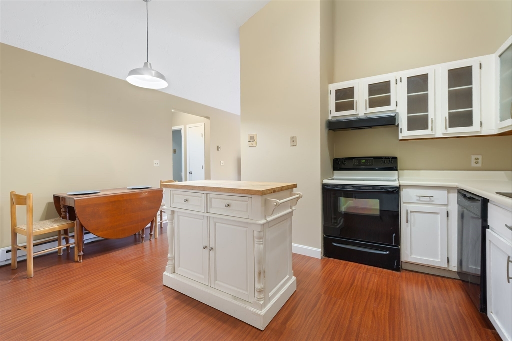 46 Gibbs Street, Unit 4D Worcester, MA 01607 - Photo 6 of 21 a kitchen with stainless steel appliances granite countertop a stove a sink dishwasher and a refrigerator with wooden floor