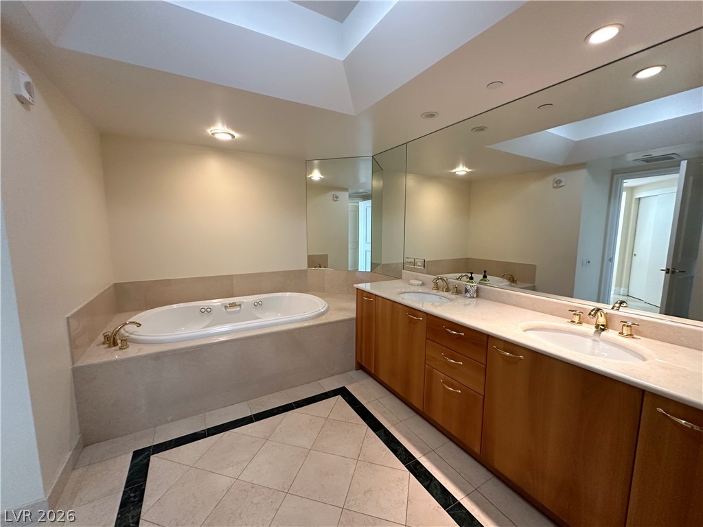 2747 Paradise Road, Unit 1706 Las Vegas, NV 89109 - Photo 18 of 35 Luxurious bath with soaking tub and expansive vanity mirrors offers a serene retreat.
