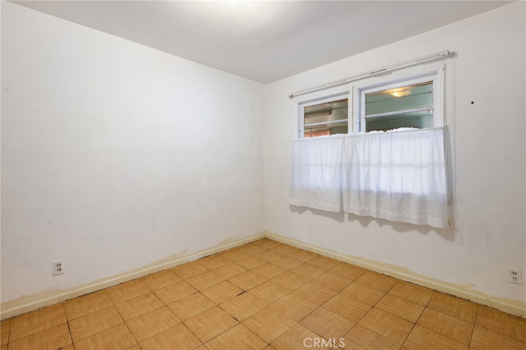 12128 161st Street Norwalk, CA 90650 - Photo 11 of 18 a view of an empty room with wooden floor and a window