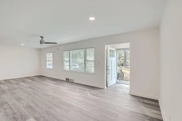 an empty room with wooden floor and windows