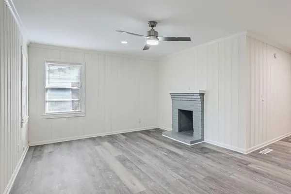 an empty room with windows and fireplace