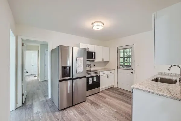 a kitchen with stainless steel appliances granite countertop a sink stove and refrigerator