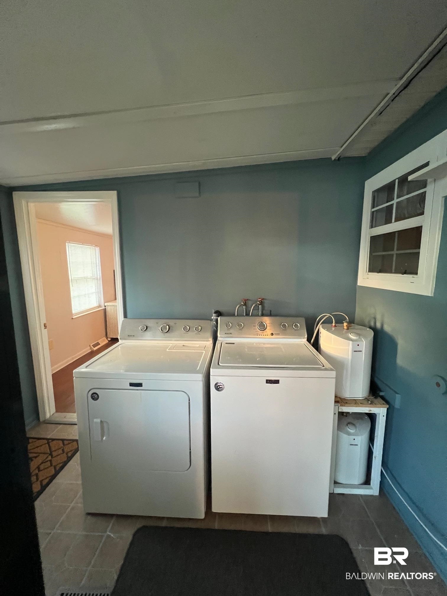 698 Escambia Loop Lillian, AL 36549 - Photo 12 of 16 Laundry room with washer and clothes dryer and tile patterned flooring