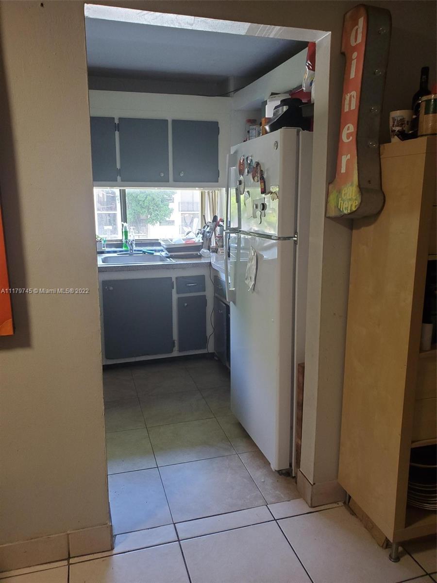 17021 North Bay Road, Unit 329 Sunny Isles Beach, FL 33160 - Photo 11 of 18 a kitchen with a refrigerator and window
