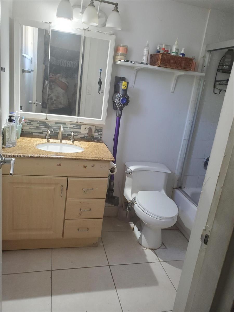17021 North Bay Road, Unit 329 Sunny Isles Beach, FL 33160 - Photo 15 of 18 a bathroom with a granite countertop toilet sink and mirror
