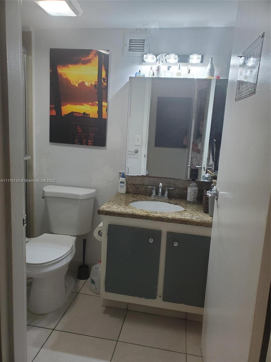 17021 North Bay Road, Unit 329 Sunny Isles Beach, FL 33160 - Photo 16 of 18 a bathroom with a toilet sink and mirror