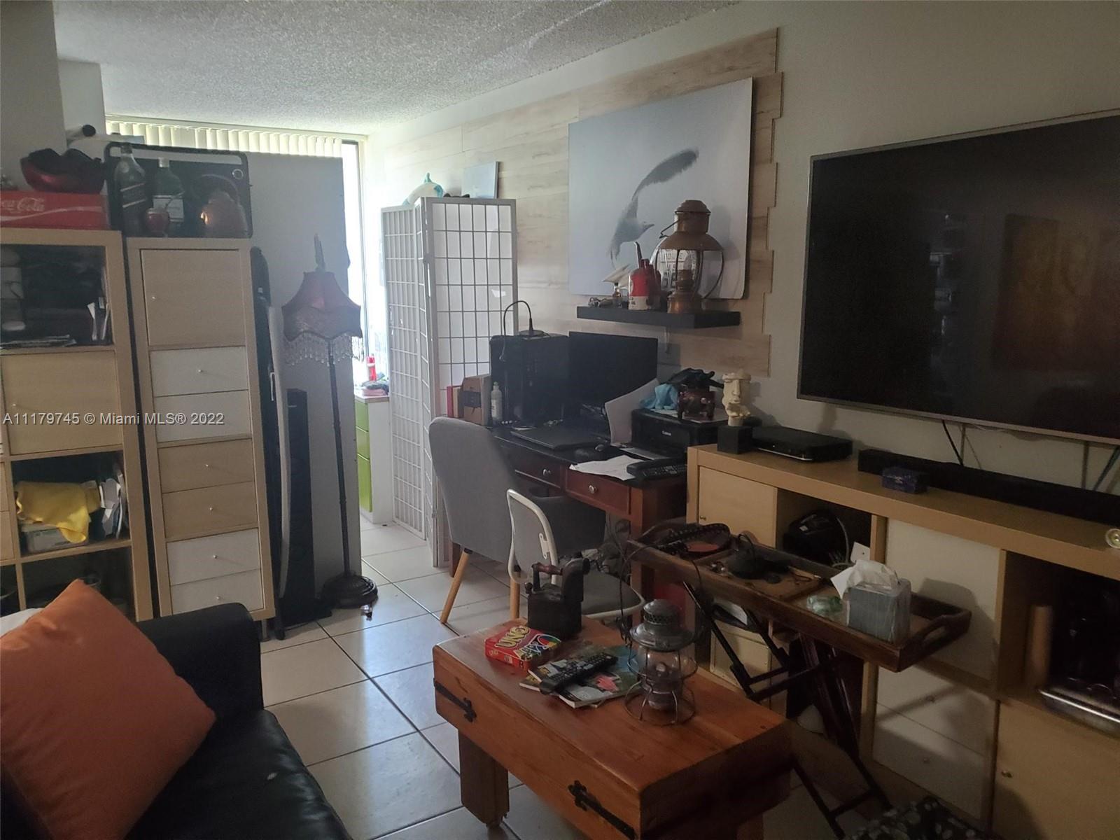 17021 North Bay Road, Unit 329 Sunny Isles Beach, FL 33160 - Photo 10 of 18 a living room with furniture and a flat screen tv