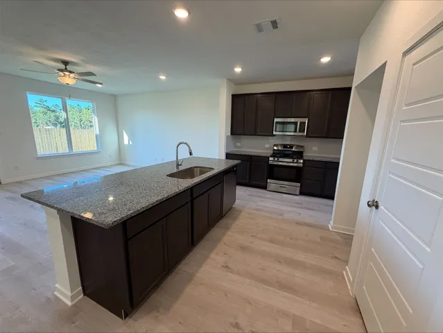 a kitchen with a stove a sink a refrigerator and a microwave