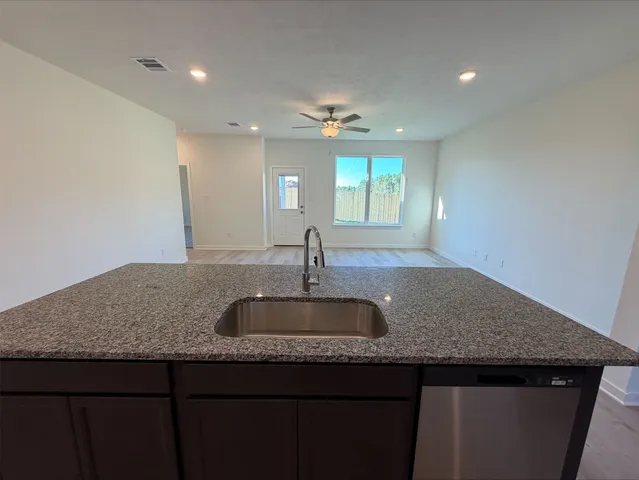 a kitchen with granite countertop a sink and dishwasher