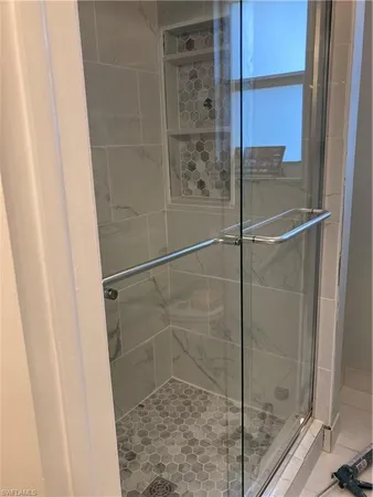 a bed sitting in a bedroom next to a window with a chandelier