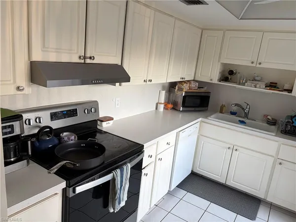 a kitchen with a stove and white cabinets