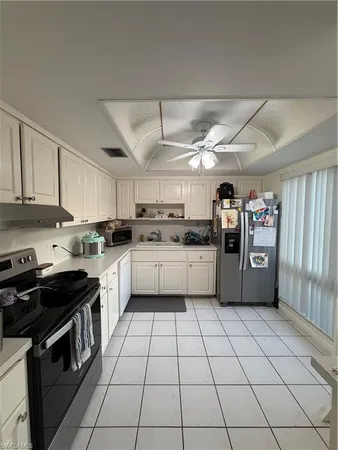 a kitchen with a white cabinets a sink and white stainless steel appliances