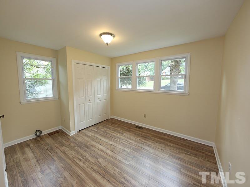 3433 Cheyenne Road Raleigh, NC 27609 - Photo 8 of 13 a view of an empty room with wooden floor and a window