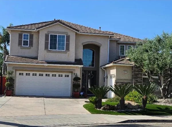 a front view of a house with plants and garage